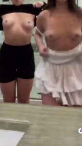 Two friends making sexy fun TikTok by flashing their tits in the bathroom